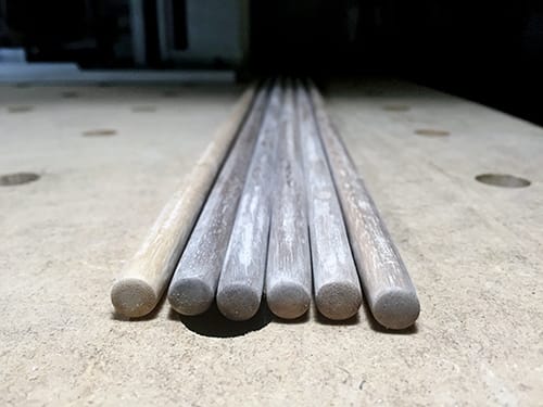Six rounded wooden poles lying on a table
