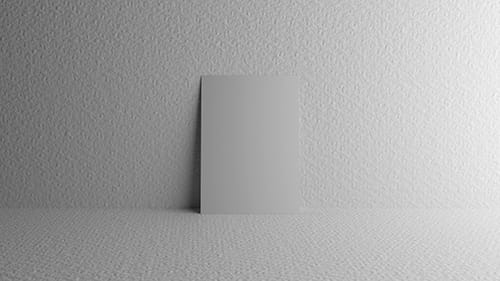 A piece of card leaning against a wall in a white room