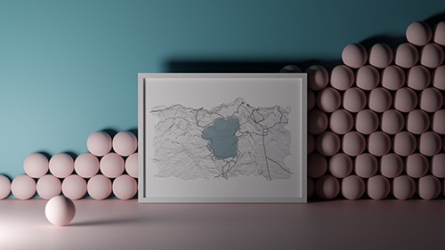 A map in a white picture frame leaning against a wall in a room with pink floors, a blue wall, and pink balls stacked against the wall
