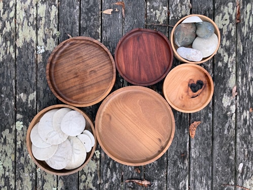 Six circular wooden dishes on an old table