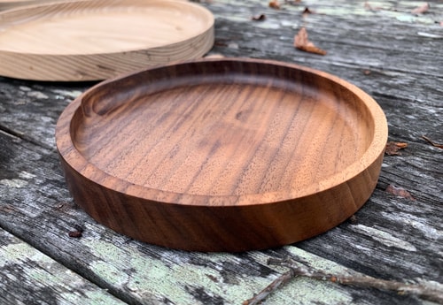 A circular wooden dish on an old table