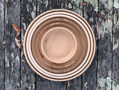 Six circular wooden dishes of decreasing diameter, stacked inside each other